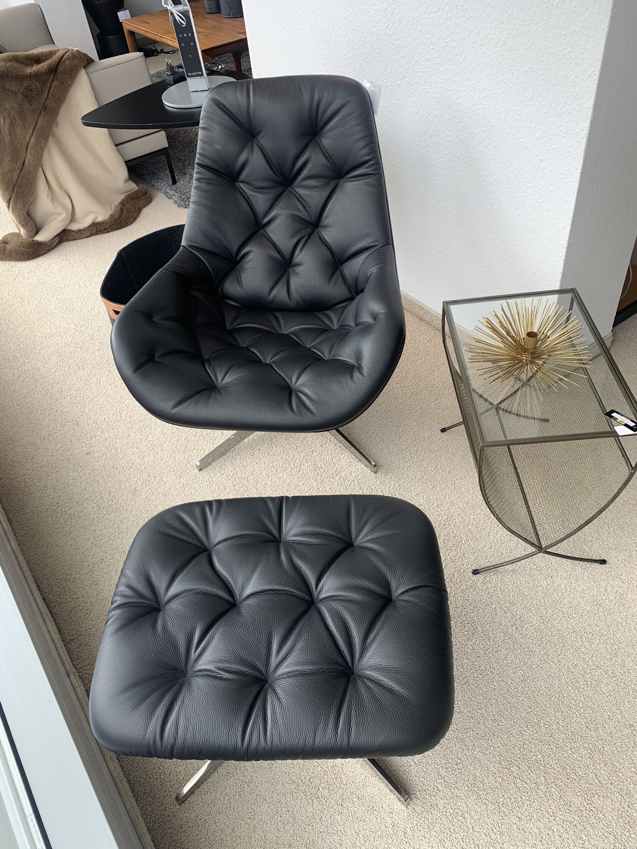 Schwarzer Sessel mit Beistellhocker